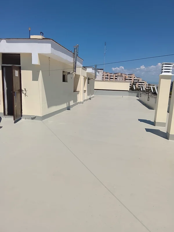 Copertura piana con rivestimento chiaro, risvolti perimetrali e accesso al locale tecnico.