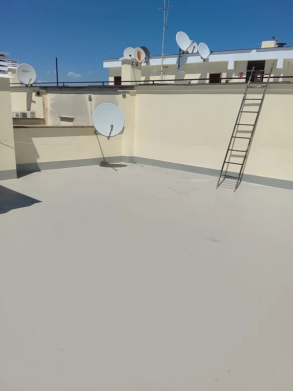 Vista di un angolo della copertura, con parapetti, antenna e scala di accesso.