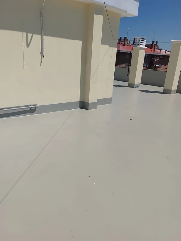 Raccordo del rivestimento chiaro alla base di una parete e intorno agli elementi della copertura.