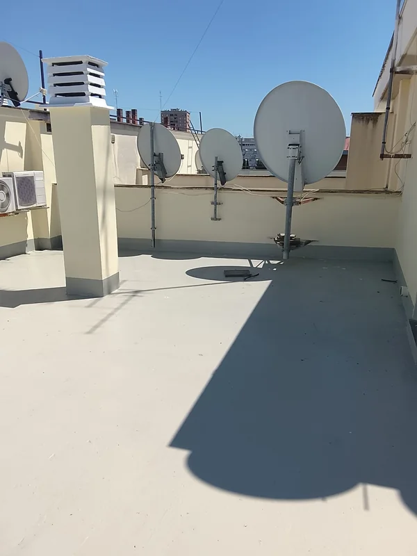 Copertura con antenne paraboliche, comignolo e fascia di raccordo lungo il perimetro.