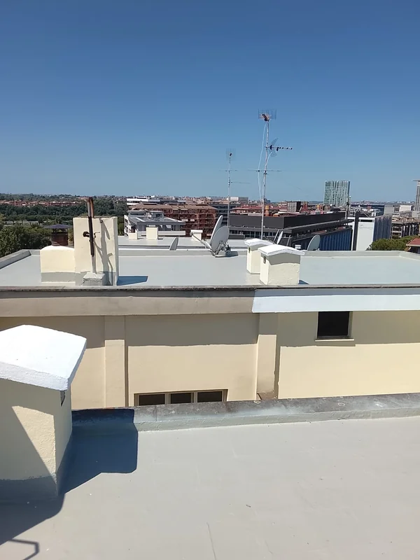 Panoramica delle coperture piane con parapetti, comignoli e antenne.