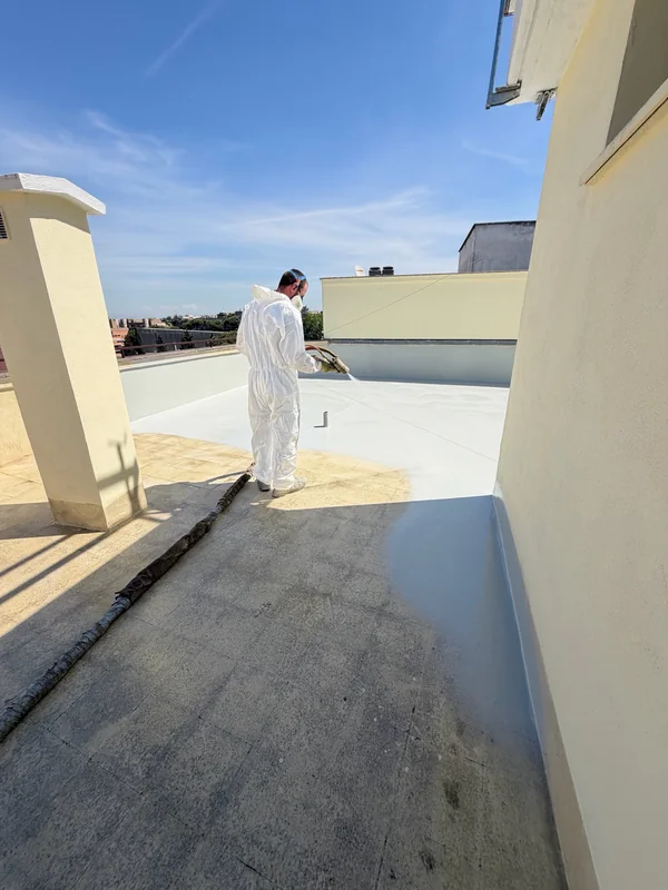 Applicazione a spruzzo del rivestimento chiaro, con passaggio tra superficie trattata e superficie esistente.