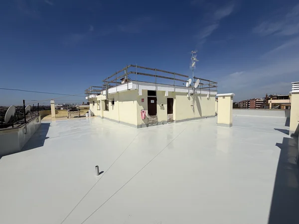 Panoramica della copertura piana con rivestimento chiaro, locali tecnici e comignoli.