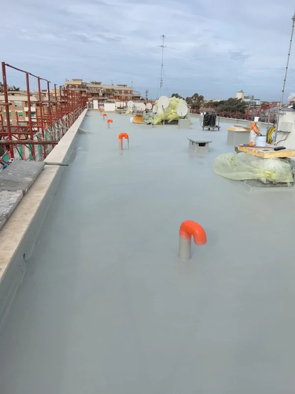 Copertura piana con tubazioni emergenti, antenne protette e raccordi lungo i parapetti.