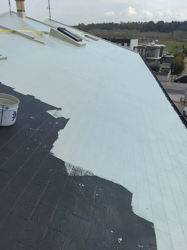 Copertura inclinata con lucernario, rivestimento chiaro e passaggio alla porzione scura non ancora rivestita.