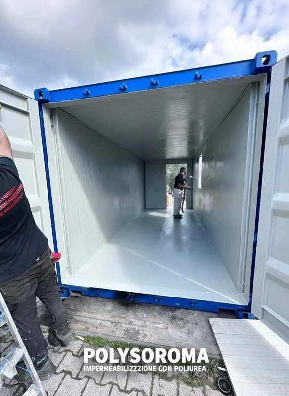 Lavorazione all’interno di un container con superfici rivestite e operatore con attrezzatura a spruzzo.