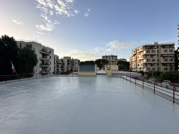 Ampia copertura piana con rivestimento grigio e ringhiere perimetrali, vista verso i locali tecnici.