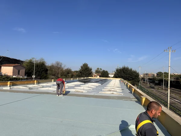 Una fase di lavoro sulla copertura con pannelli isolanti e raccordi lungo i parapetti.