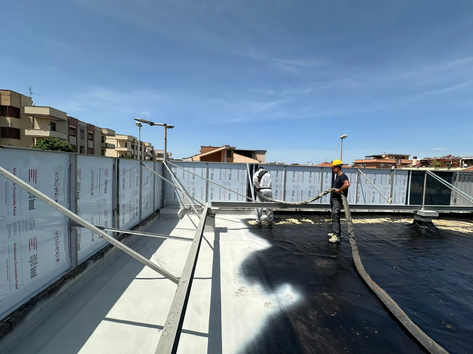 Lavorazione a spruzzo della superficie di copertura. Foto reale del team al lavoro.
